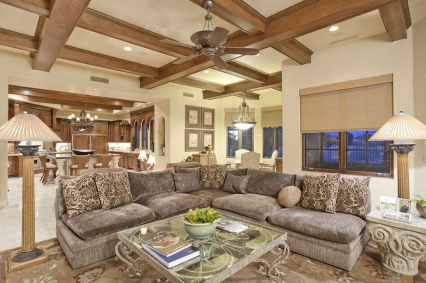 Room with sectional couch, marble flooring and wood coffered ceiling