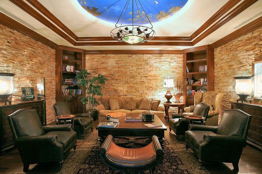 Room with stacked stone walls and blue and gold ceiling mural