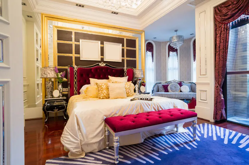 Luxury bedroom with bright color decor, bed bench, sitting area and tray ceiling