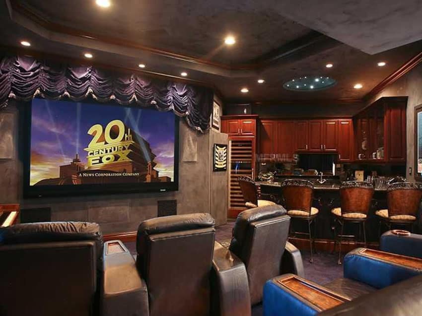 Custom home bar in movie room with comfortable seating