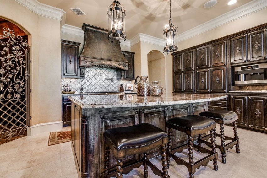 Mediterranean style kitchen with wrought iron door, wood cabinetry and cream walls