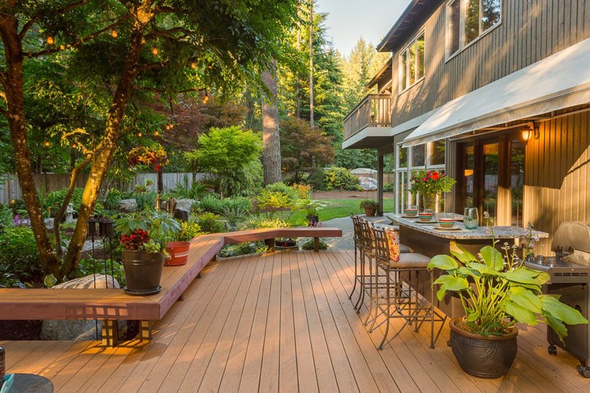 Deck next to garden with outdoor bar and long bench seating