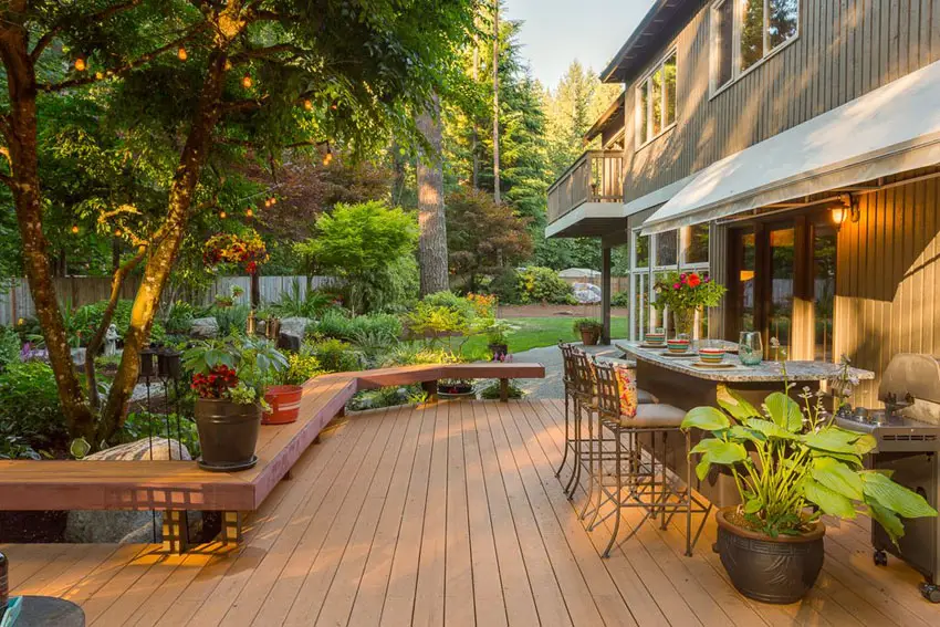 Deck next to garden with outdoor bar and long bench seating