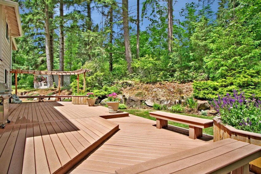 Deck with pergola and benches overlooking landscaped backyard garden