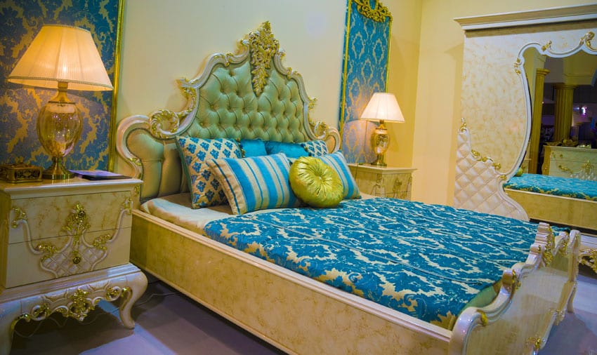 Elegant bedroom with decorative bed, tufted headboard and bright blue bedding