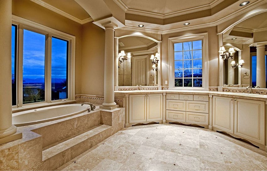 High end master bathroom with elevated bathtub with views and marble flooring tray ceiling