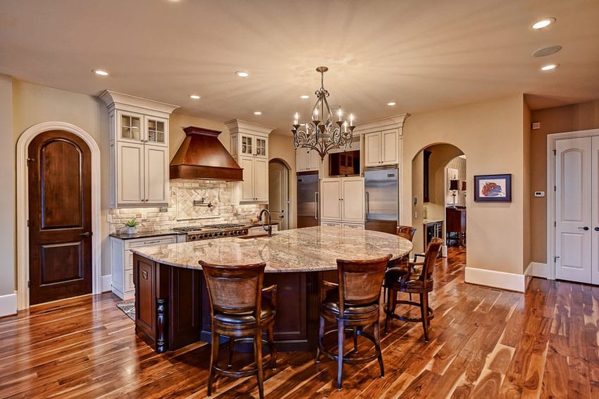 Kitchen with semi circle island, iron candle light chandelier and dining stools