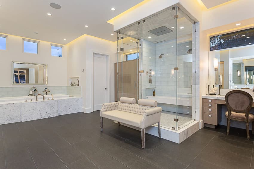 Beautiful master bathroom with large frameless shower in center of room and porcelain floor tile