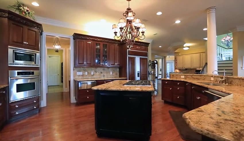 Large open kitchen with dark center island wood flooring and glass front cabinets