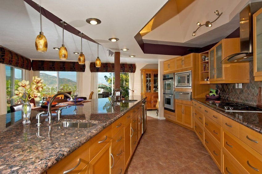 Light brown cabinet kitchen with baltic brown granite and pendant lights