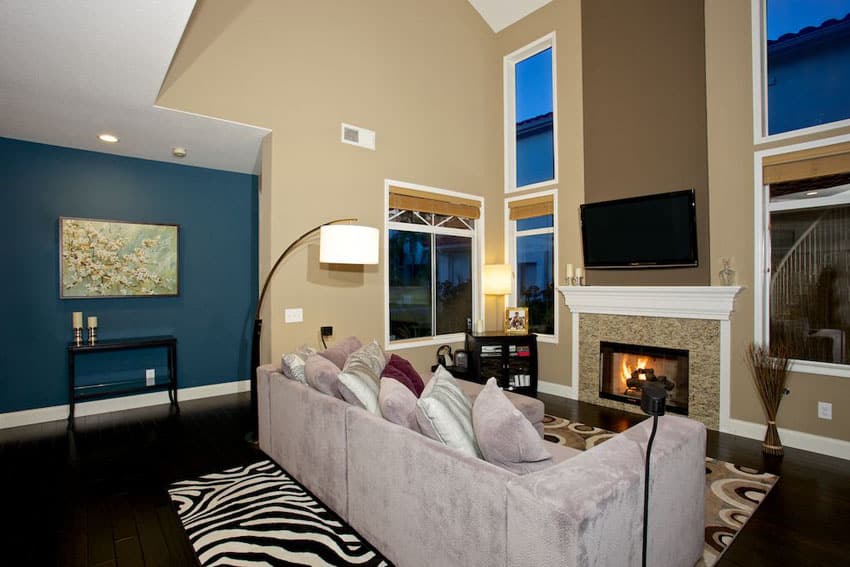 Living room design with blue wall fireplace and high ceilings