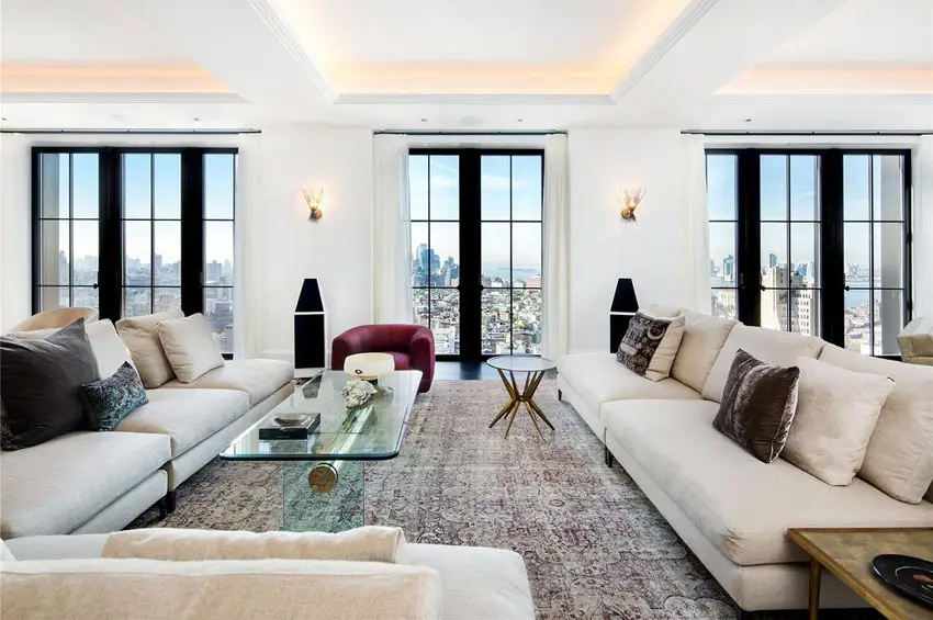 Glass pane windows, white cushions and reddish brown rug