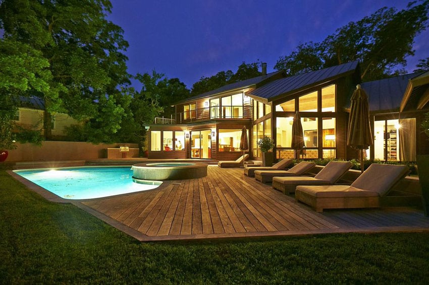 Luxury backyard with wood deck next to swimming pool