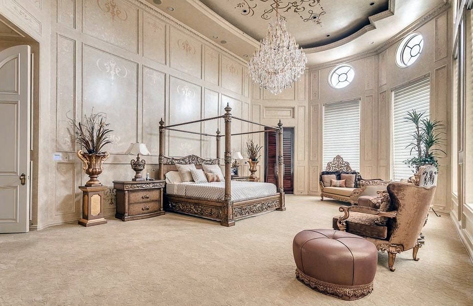 bedroom with spacious open layout, high ceilings, crystal chandelier and canopy bed