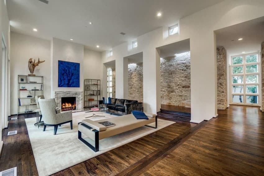 Luxury contemporary living room with high ceiling skylights and stone accent wall