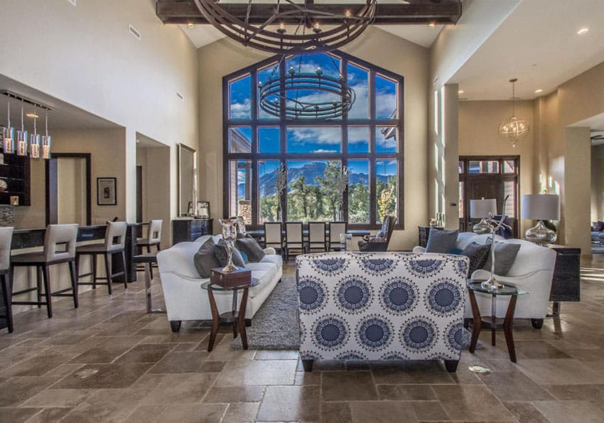 Room with wall of windows and large circular wrought iron chandeliers