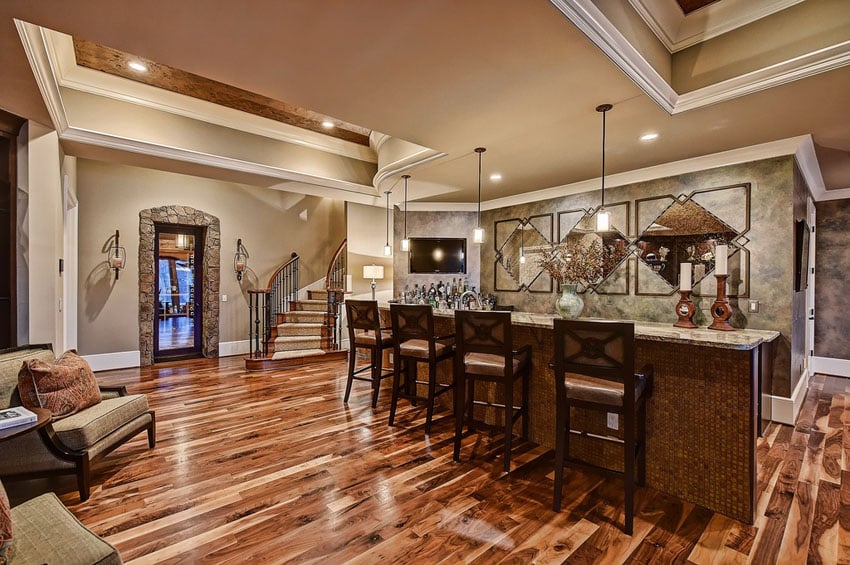 Luxury custom home bar with mosaic tile, pendant lights and hardwood floors