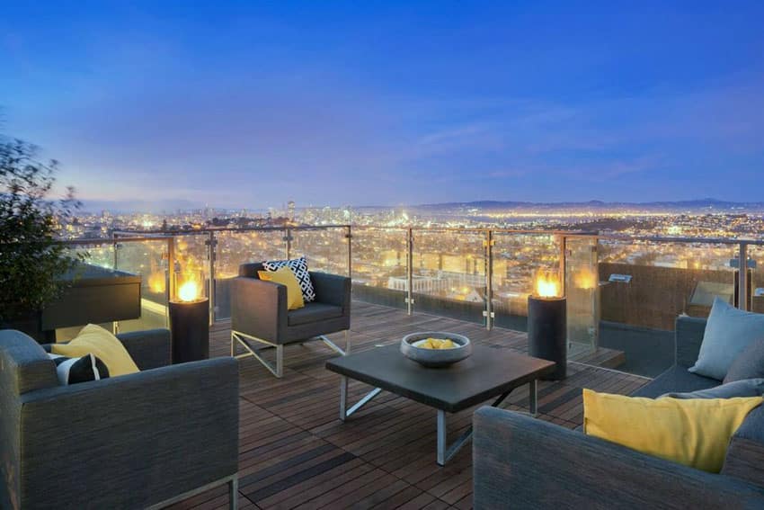 Luxury deck with modern chairs glass railings and city views