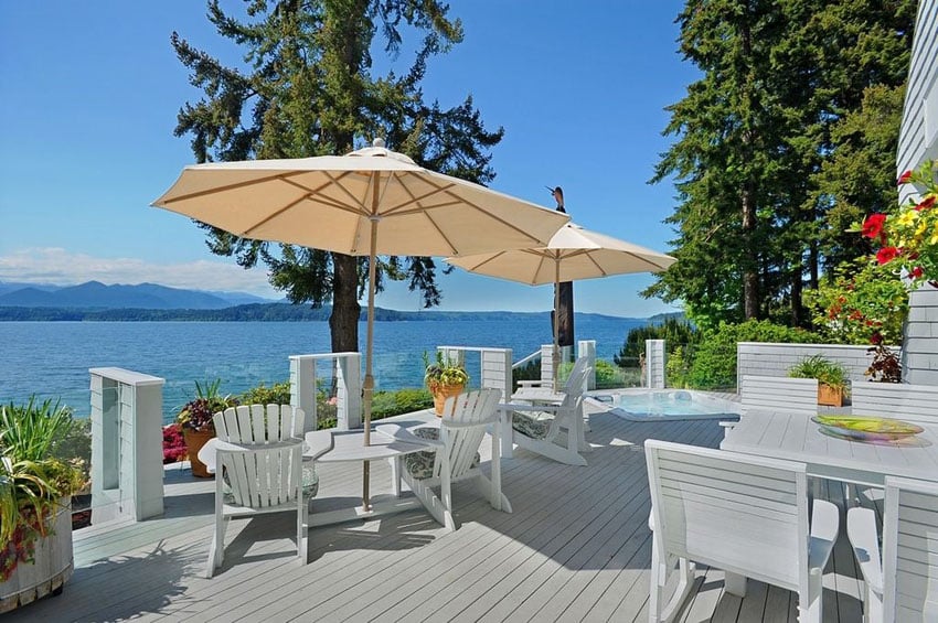 Luxury deck with white outdoor furniture and waterfront views