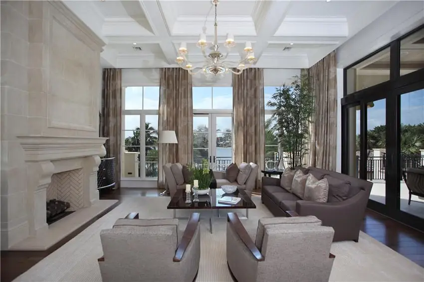 Luxury living room with corner layout with fireplace coffered ceiling and chandelier