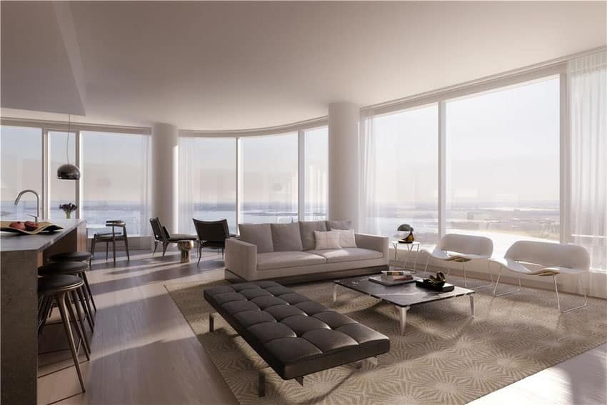 Luxury living room with muted design theme and wraparound window views of waterfront