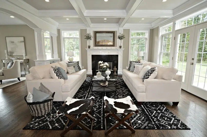 White large sofa chairs with black accent pillows and carpet and oak flooring 