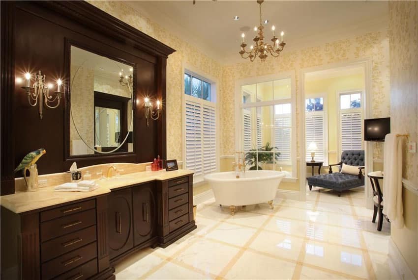 Luxury master bathroom with clawfoot tub with gold feet and marble flooring