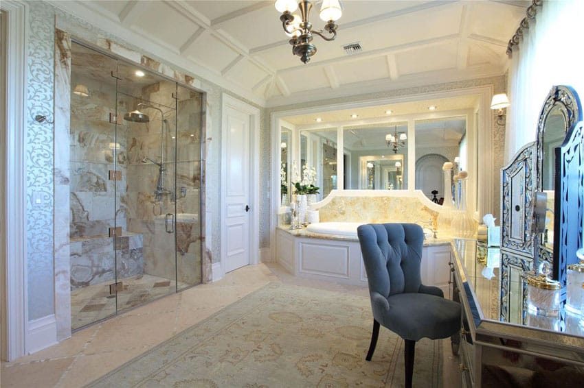 Bathroom with metallic wall paper, mirrors with white frames and shower with travertine tiles