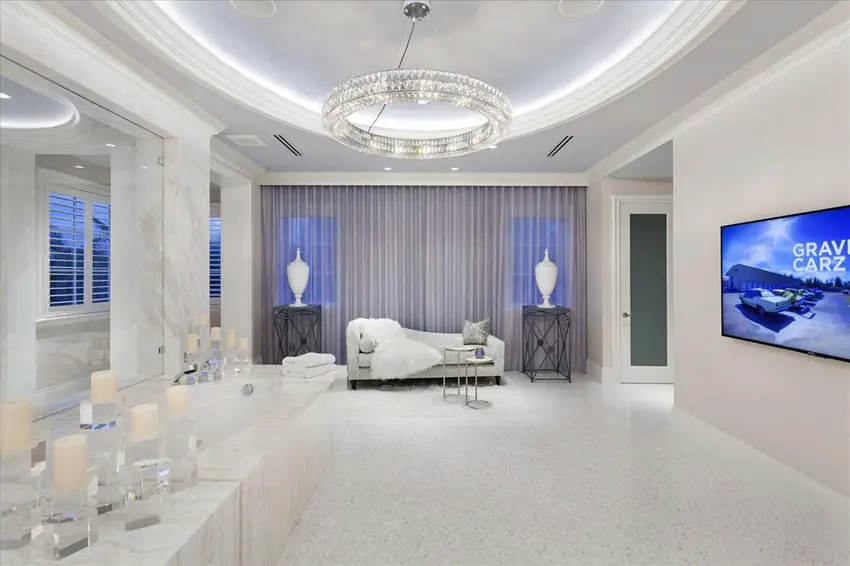 Luxury master bathroom with round tray ceiling with modern circular light and daybed