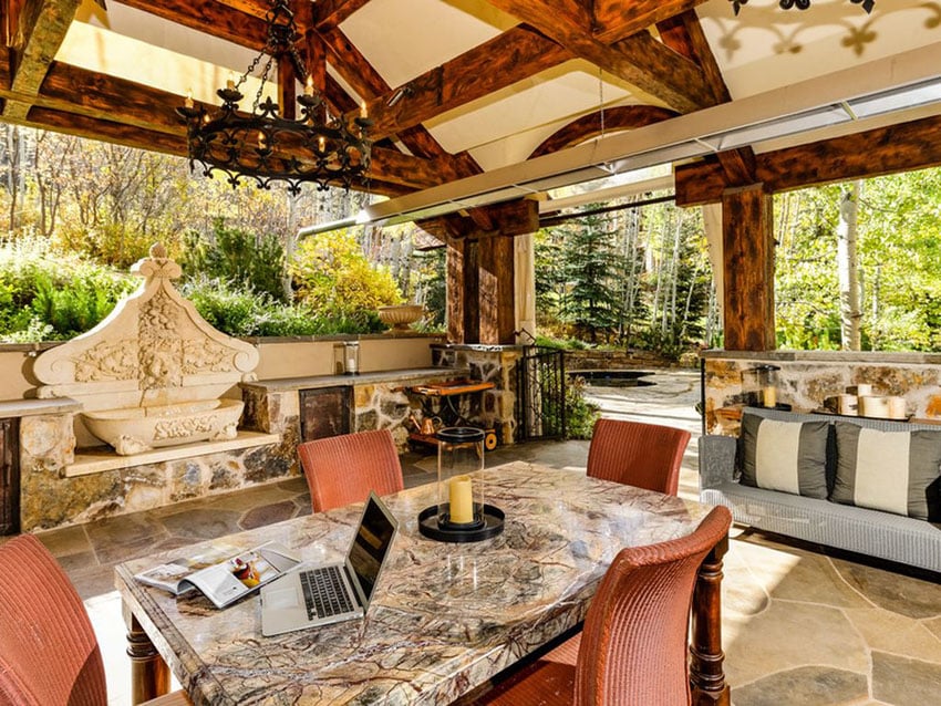 Fountain, granite table and rustic chandelier in patio are