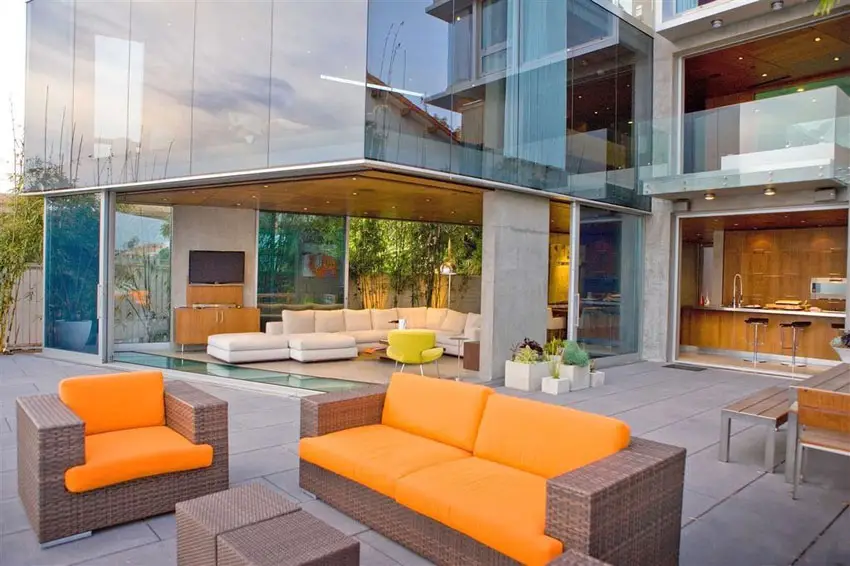 Luxury patio with synthetic rattan furniture with bright orange accent cushions
