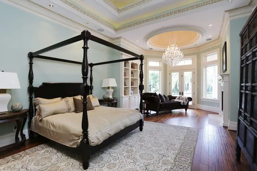 Luxury traditional master bedroom with four post bed chandelier and sitting area