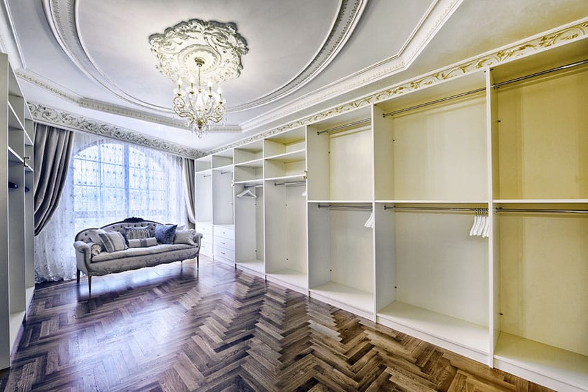 Luxury walk in closet with chandelier and wood flooring