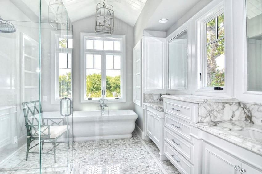 Bathroom with hexagonal mosaic tiles, clear glass partitions and tub by the swing window