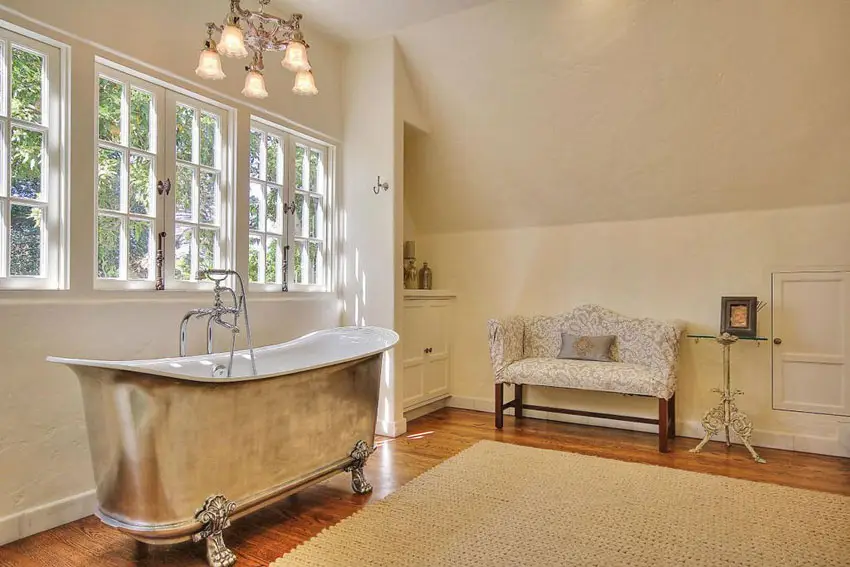 Master bathroom with aged chrome bathtub, loveseat and carpet
