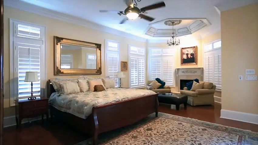 Master bedroom with wood floors crown molding fireplace and tray ceiling