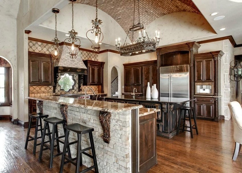 Kitchen with natural stone island bar adorned with crown molding and sandy tan backsplash