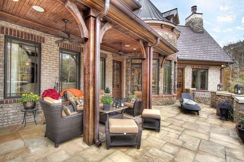 Classic English patio with aged stone floor tiles and wood columns