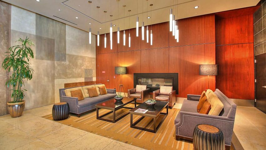 Modern formal living room with wood grain accent wall and cylinder pendant lights