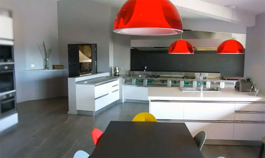 Modern kitchen with bright red lamps and white cabinets