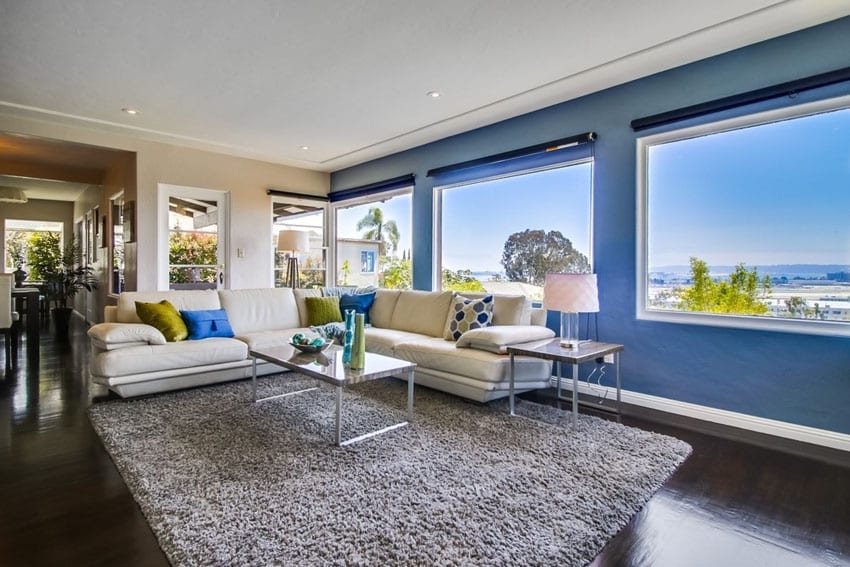 modern living room with blue wall and picture window views of city