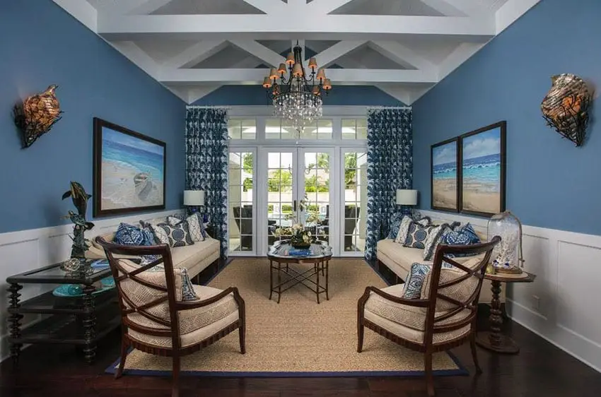 Nautical blue themed living room with white wainscoting and vaulted ceiling