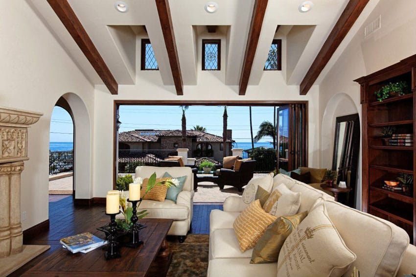 Ocean view craftsman living room with exposed beams, high ceiling windows and dark wood floors