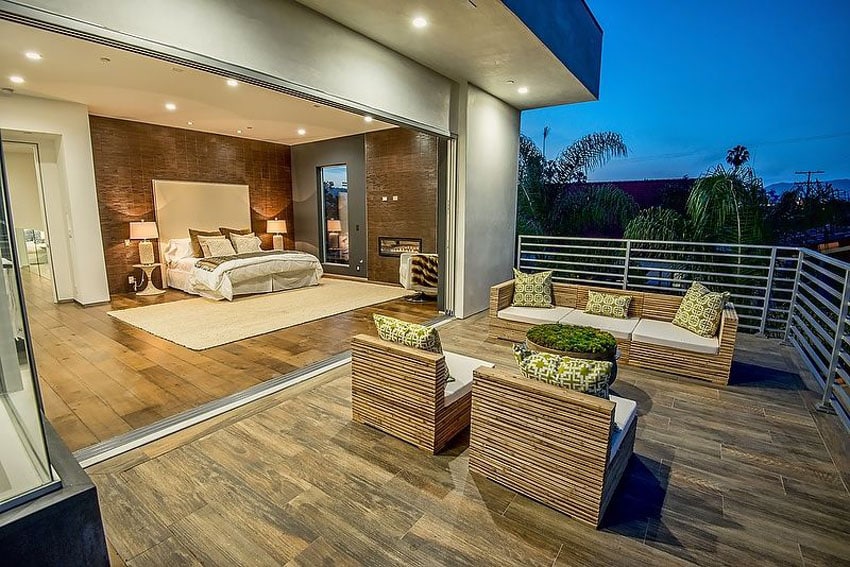 Outdoor deck steps from bedroom with patio furniture and large retractable door