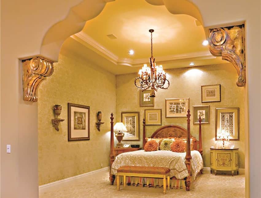 Palace style luxury bedroom with intricate archways, ornate wall carvings and amazing brass chandelier