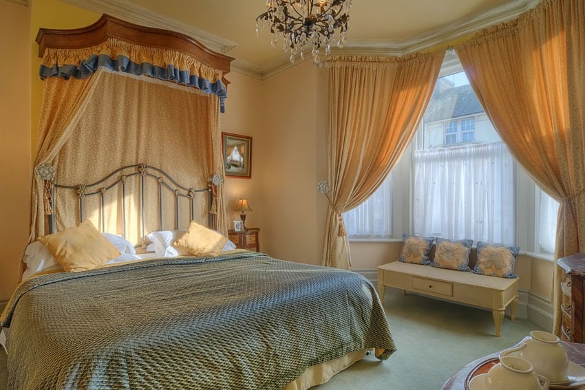 Pretty bedroom design with flowing curtains and glass chandelier