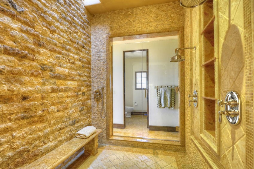 Large rain shower with stone walls and tile floors