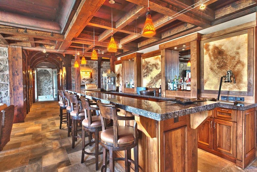 Rustic wood home bar with granite counters and tile flooring
