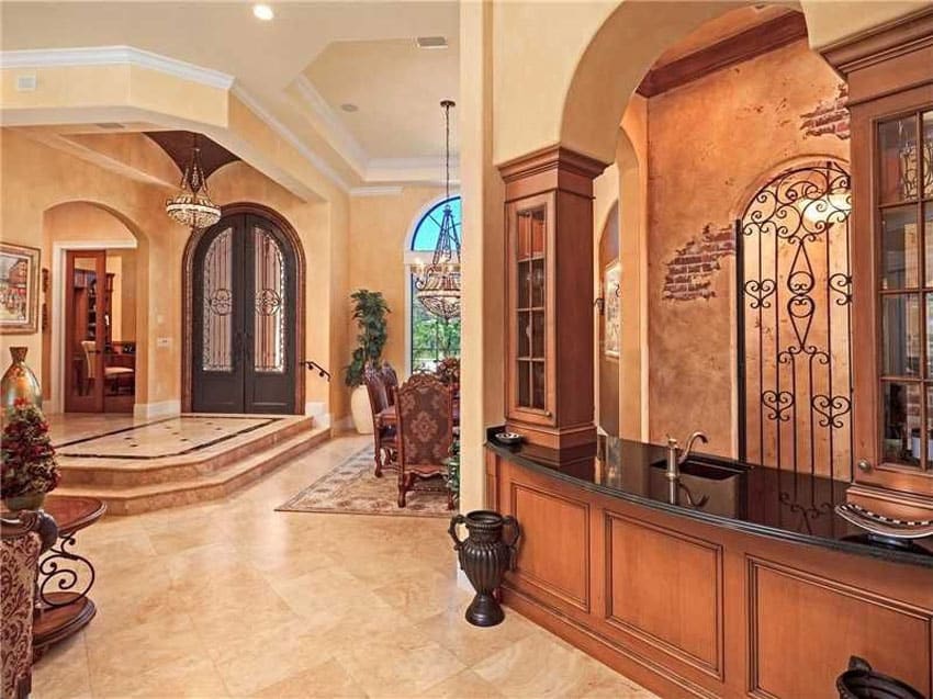 Foyer with wet bar area, arched door and view of the dining room