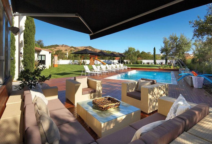 Swimming pool deck with outdoor furniture and canopy